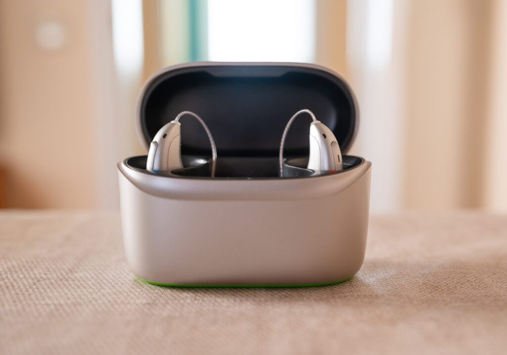 Rechargeable receiver-in-canal hearing aids in an open charging case, for battery tips from West Valley Hearing Center in Woodland Hills, CA